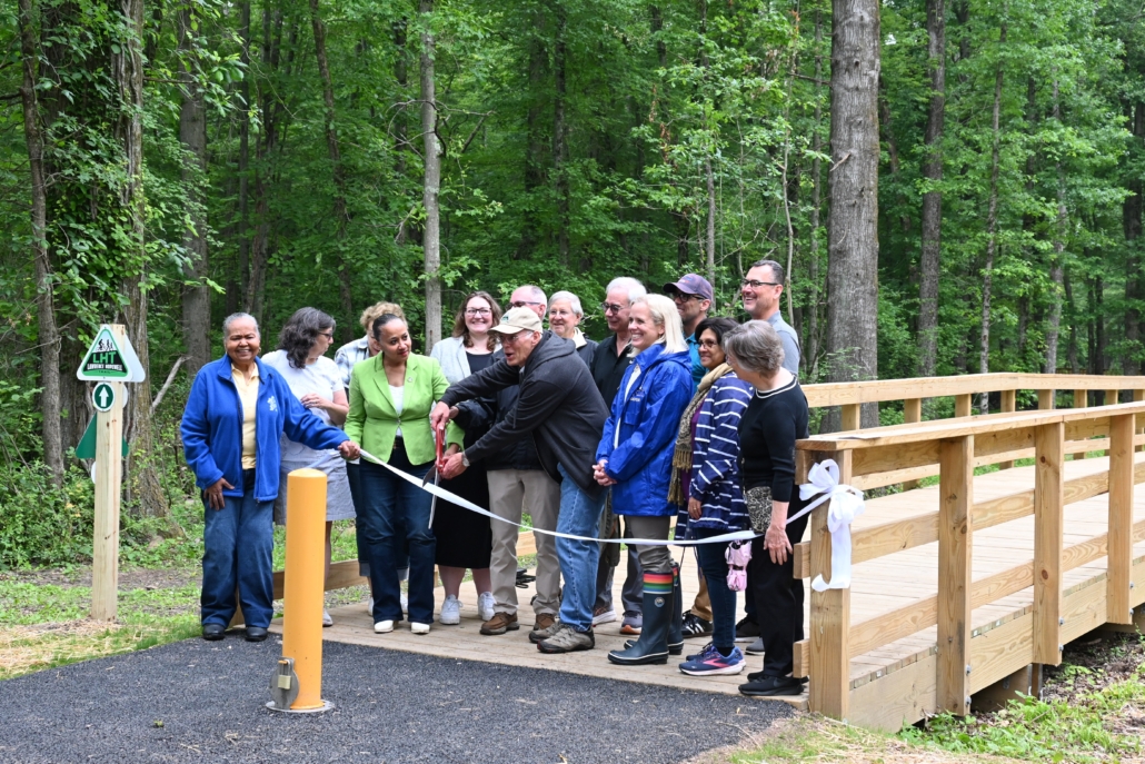 Group cutting a large ribbon across the new section of trail