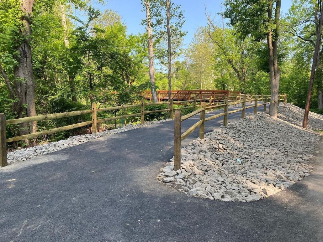New paved trail leading to a bridge that creates a cross over the Darby Creek